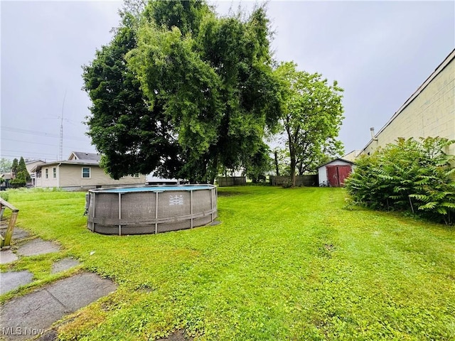 1201 Jackson St SW, Massillon, OH 44647 - view of green lawn with an outdoor pool and a storage shed