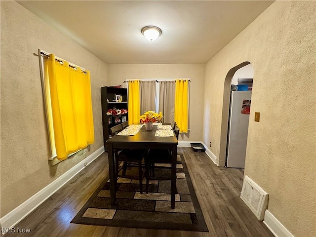 1201 Jackson St SW, Massillon, OH 44647 - dining space with arched walkways, dark wood finished floors, and a textured wall