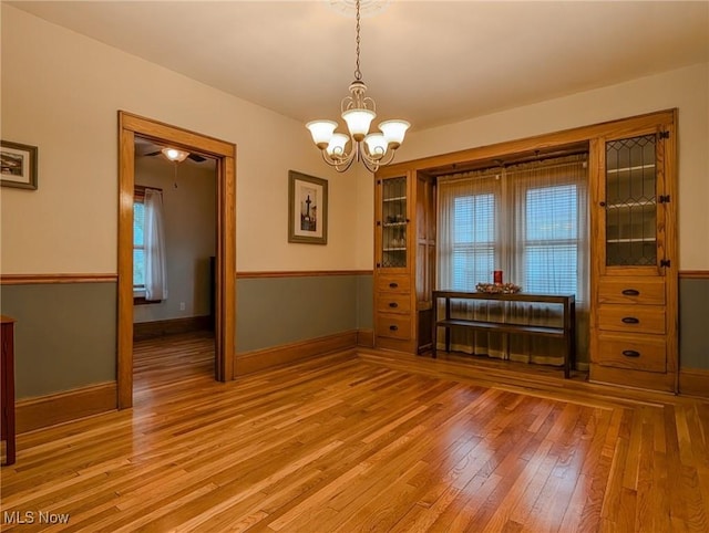 414 W Maple St, Hartville, OH 44632 - unfurnished dining area with light wood finished floors, a chandelier, and healthy amount of natural light