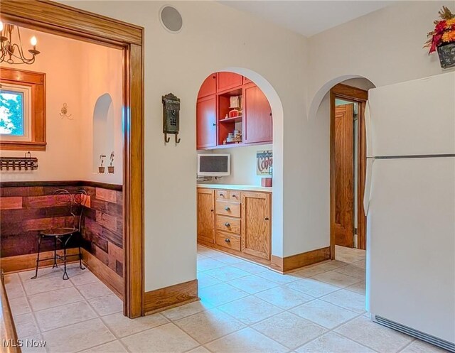 414 W Maple St, Hartville, OH 44632 - hall featuring a chandelier, light tile patterned flooring, and arched walkways