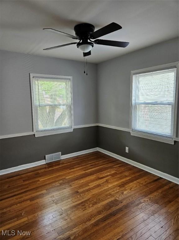 21731 Nicholas Ave, Euclid, OH 44123 - empty room with healthy amount of natural light, dark wood-style flooring, and a ceiling fan