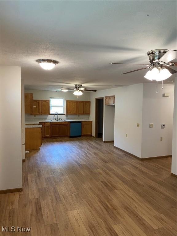 4920 Thomas Blvd, Geneva, OH 44041 - kitchen featuring dishwasher, brown cabinetry, a ceiling fan, wood finished floors, and light countertops