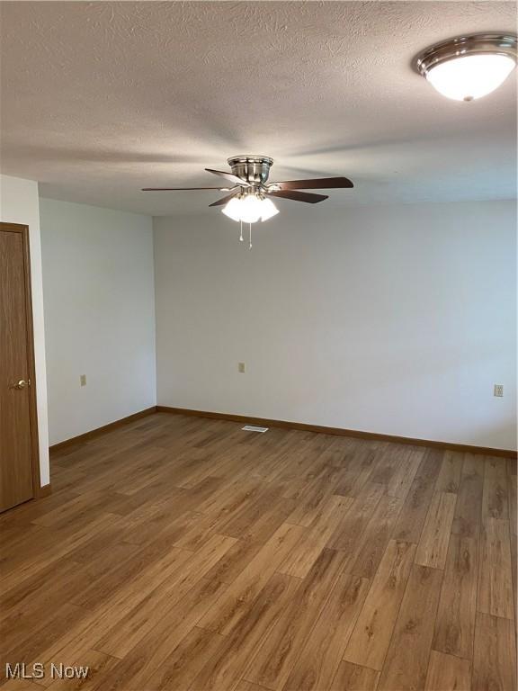 4920 Thomas Blvd, Geneva, OH 44041 - spare room with light wood-style floors, ceiling fan, and a textured ceiling