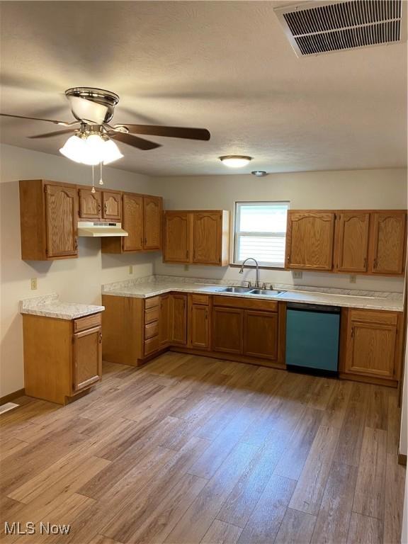 4920 Thomas Blvd, Geneva, OH 44041 - kitchen with dishwasher, brown cabinets, under cabinet range hood, light wood-type flooring, and ceiling fan