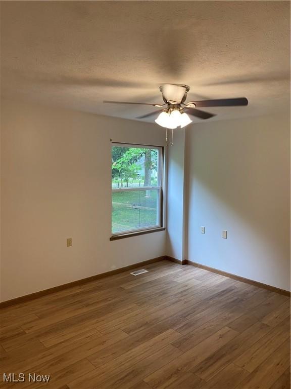 4920 Thomas Blvd, Geneva, OH 44041 - unfurnished room with wood finished floors, a ceiling fan, and a textured ceiling