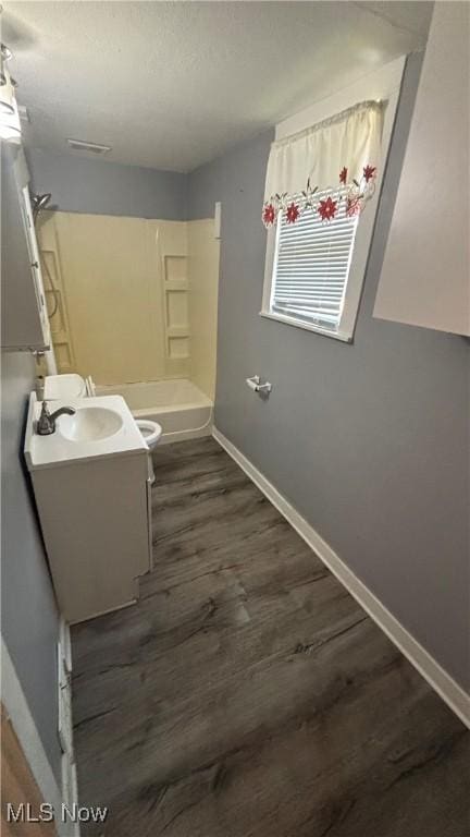 1682 E 33rd St, Lorain, OH 44055 - bathroom with vanity, wood finished floors, tub / shower combination, and a textured ceiling