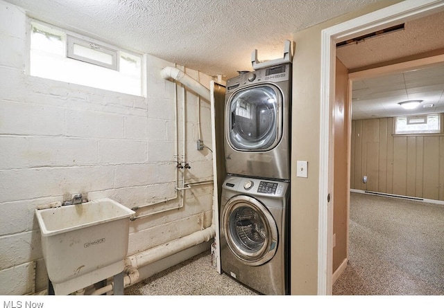 3371 Brecksville Rd, Richfield, OH 44286 - washroom featuring stacked washer and clothes dryer, a textured ceiling, and concrete block wall