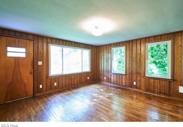 3371 Brecksville Rd, Richfield, OH 44286 - entryway with hardwood / wood-style floors, wood walls, and a textured ceiling