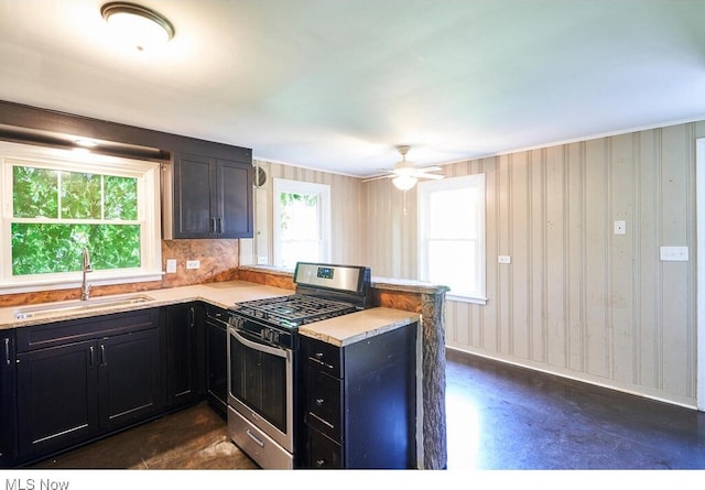 3371 Brecksville Rd, Richfield, OH 44286 - kitchen with stainless steel gas range, a peninsula, light countertops, dark cabinets, and ceiling fan