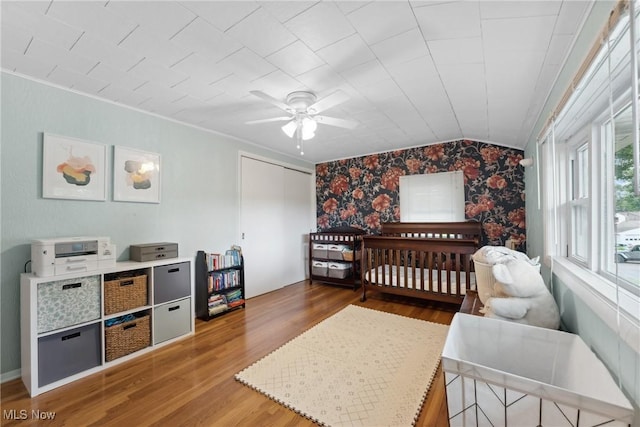 4324 Ormond Dr, New Franklin, OH 44319 - bedroom with an accent wall, wallpapered walls, wood finished floors, a closet, and a ceiling fan