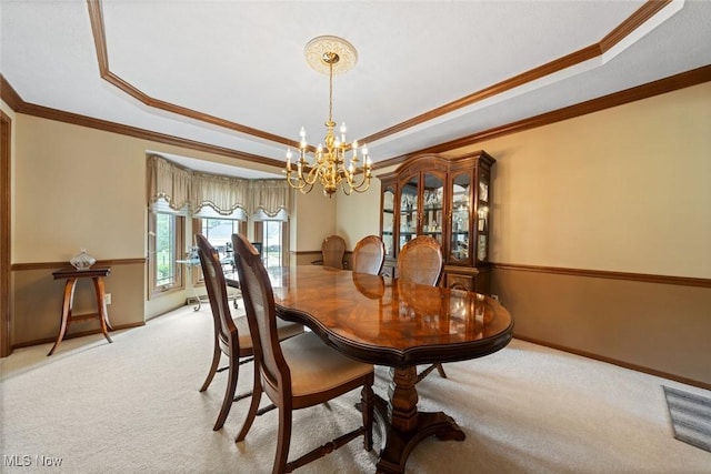 7700 Sparrow Flight Dr, Seven Hills, OH 44131 - dining space featuring a tray ceiling, light colored carpet, a chandelier, and crown molding