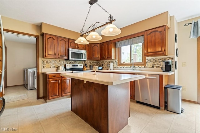 7700 Sparrow Flight Dr, Seven Hills, OH 44131 - kitchen featuring appliances with stainless steel finishes, washing machine and dryer, light countertops, and decorative backsplash