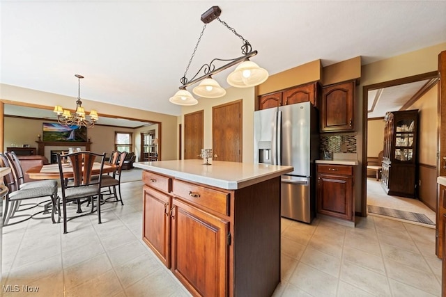 7700 Sparrow Flight Dr, Seven Hills, OH 44131 - kitchen with stainless steel fridge with ice dispenser, light countertops, a chandelier, a center island, and decorative light fixtures
