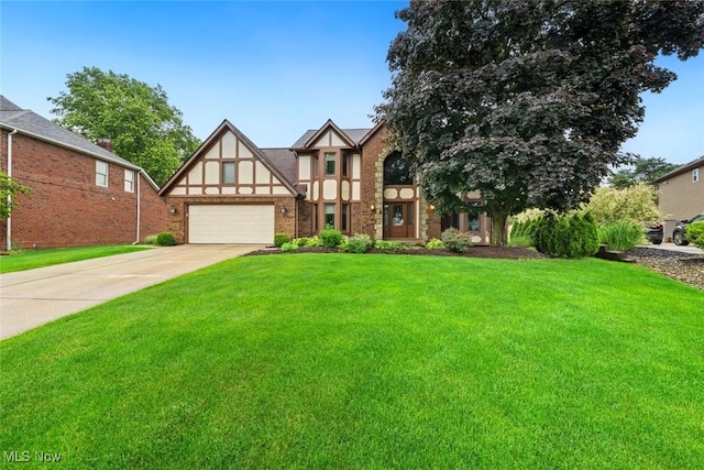 7700 Sparrow Flight Dr, Seven Hills, OH 44131 - tudor house featuring a front yard, driveway, an attached garage, and brick siding