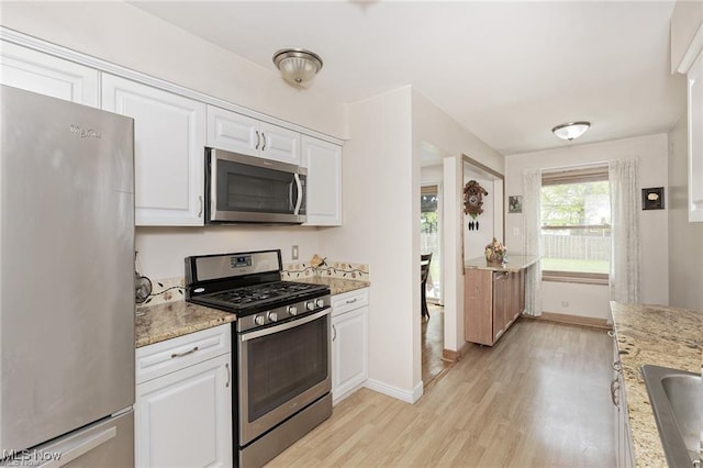 4938 N Sedgewick Rd, Lyndhurst, OH 44124 - kitchen featuring stainless steel appliances, light wood finished floors, white cabinetry, and light stone counters
