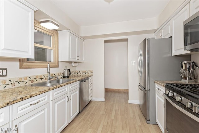 4938 N Sedgewick Rd, Lyndhurst, OH 44124 - kitchen with stainless steel appliances, light wood-type flooring, white cabinets, and light stone countertops