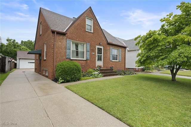 5910 Gerald Ave, Parma, OH 44129 - view of front of house with brick siding, a front yard, roof with shingles, and a detached garage