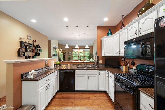 637 N Ridgecliff St, Tallmadge, OH 44278 - kitchen featuring black appliances, white cabinetry, light wood-style flooring, a chandelier, and a peninsula