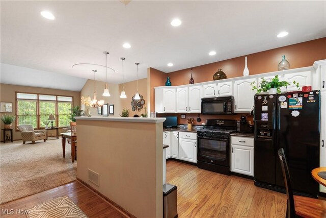 637 N Ridgecliff St, Tallmadge, OH 44278 - kitchen with black appliances, white cabinetry, light wood finished floors, a chandelier, and decorative light fixtures