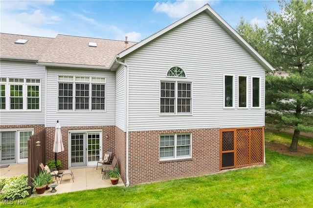 637 N Ridgecliff St, Tallmadge, OH 44278 - back of property featuring a patio area, brick siding, a lawn, and roof with shingles