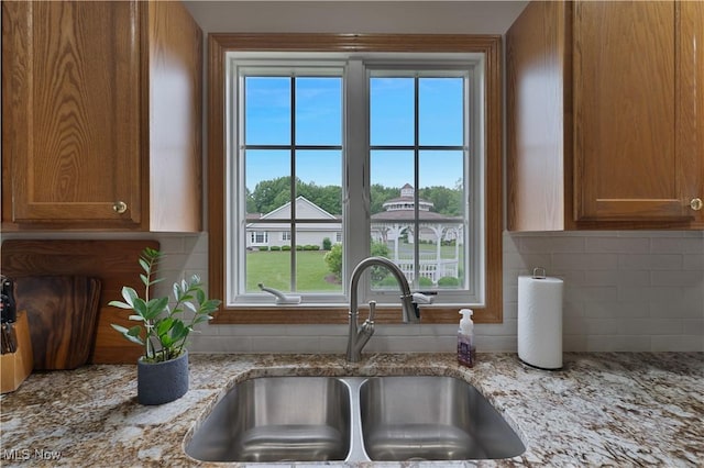 7876 Walnut St Unit B, Boardman, OH 44512 - kitchen with brown cabinets, tasteful backsplash, plenty of natural light, and light stone countertops