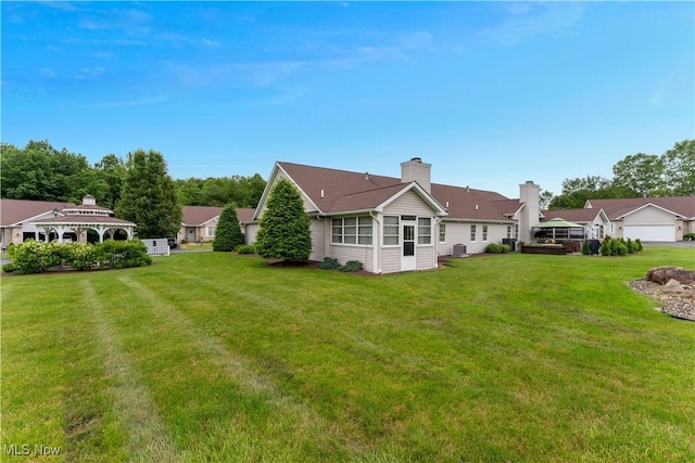 7876 Walnut St Unit B, Boardman, OH 44512 - rear view of property with a lawn, a chimney, a gazebo, and a sunroom