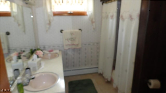 3981 Washington School Rd, New Cumberland, WV 26047 - bathroom featuring baseboard heating, double vanity, and wallpapered walls