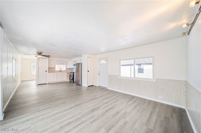 34424 Euclid Ave Unit 260, Willoughby, OH 44094 - unfurnished living room featuring light wood-type flooring, ceiling fan, and a textured ceiling