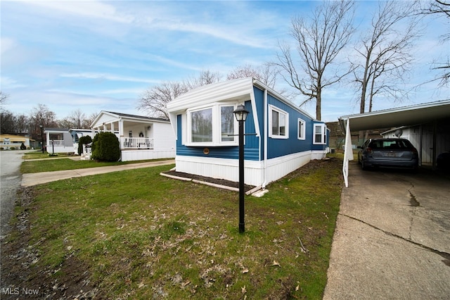 34424 Euclid Ave Unit 260, Willoughby, OH 44094 - view of side of home featuring concrete driveway, a lawn, and covered porch