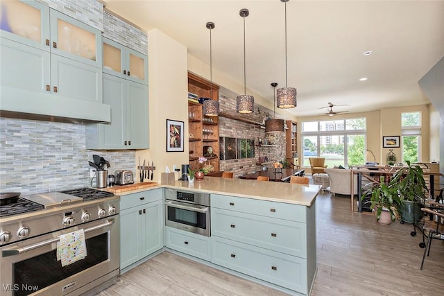1569 E 118th St Unit B, Cleveland, OH 44106 - kitchen featuring appliances with stainless steel finishes, a peninsula, ceiling fan, and decorative backsplash