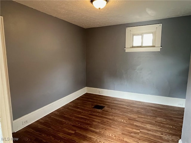 907 Lovers Ln, Akron, OH 44306 - empty room featuring a textured ceiling and dark wood finished floors