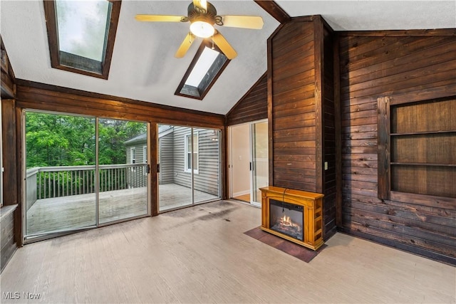 3965 Ellendale Rd, Chagrin Falls, OH 44022 - unfurnished living room featuring wooden walls, a skylight, vaulted ceiling, wood finished floors, and ceiling fan