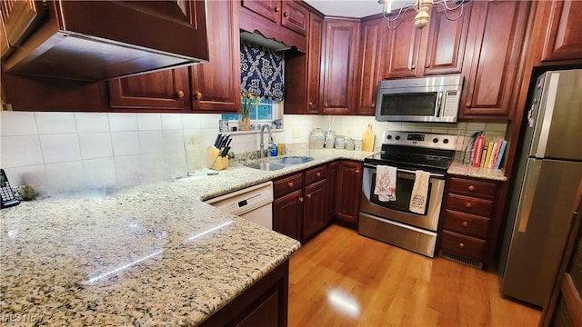 112 Laurel Ln, Washington, WV 26181 - kitchen featuring stainless steel appliances, backsplash, reddish brown cabinets, and light wood finished floors