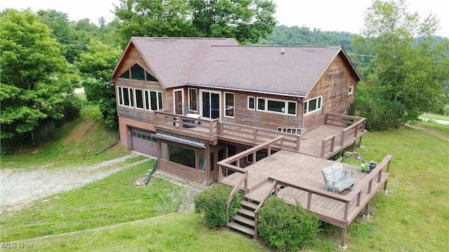 32701 Gundy Ridge Rd, Bowerston, OH 44695 - back of property with a deck, dirt driveway, a lawn, an attached garage, and a shingled roof
