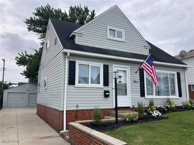 7611 Liberty Ave, Parma, OH 44129 - view of front of home with a detached garage, an outbuilding, a front lawn, and roof with shingles
