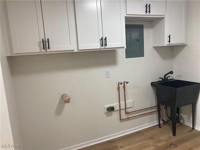7611 Liberty Ave, Parma, OH 44129 - washroom with electric panel, wood finished floors, and cabinet space