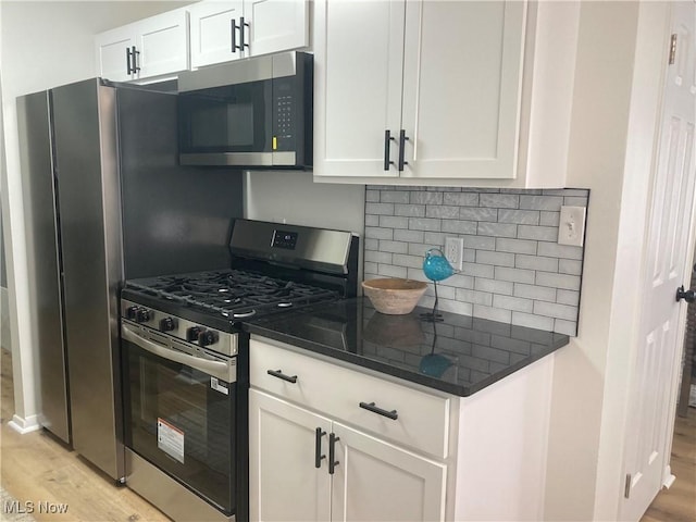 7611 Liberty Ave, Parma, OH 44129 - kitchen featuring appliances with stainless steel finishes, light wood-style flooring, tasteful backsplash, and white cabinets