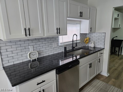 7611 Liberty Ave, Parma, OH 44129 - kitchen featuring stainless steel dishwasher, dark wood-style flooring, white cabinets, and decorative backsplash