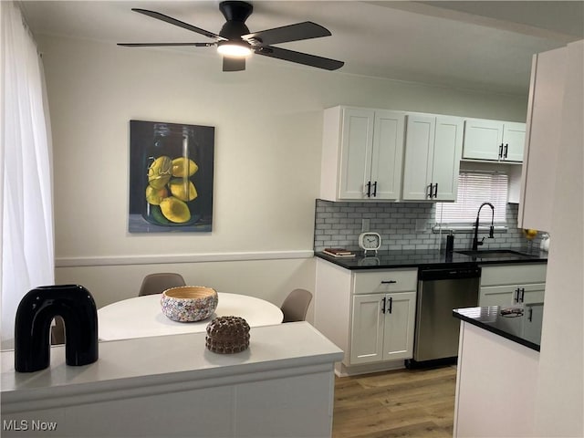 7611 Liberty Ave, Parma, OH 44129 - kitchen featuring stainless steel dishwasher, tasteful backsplash, light wood-style flooring, white cabinetry, and a ceiling fan
