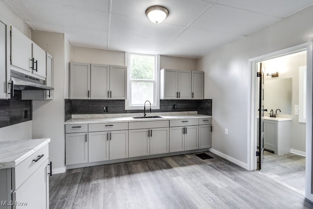 1017 Smith Ave SW, Canton, OH 44706 - kitchen featuring under cabinet range hood, gray cabinets, backsplash, and light wood-style floors