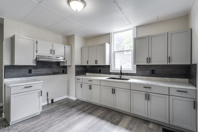 1017 Smith Ave SW, Canton, OH 44706 - kitchen featuring under cabinet range hood, gray cabinets, a drop ceiling, and tasteful backsplash