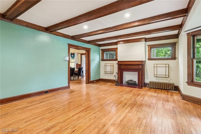 1575 E 108th St, Cleveland, OH 44106 - unfurnished living room with radiator, beamed ceiling, light wood-type flooring, and a fireplace with flush hearth