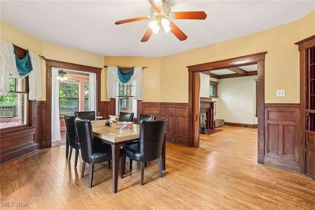 1575 E 108th St, Cleveland, OH 44106 - dining area featuring wainscoting, light wood finished floors, ceiling fan, a fireplace with flush hearth, and cooling unit