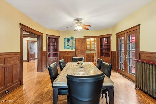 1575 E 108th St, Cleveland, OH 44106 - dining space featuring wainscoting, french doors, light wood-type flooring, and ceiling fan