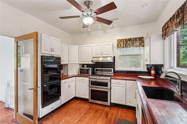 1575 E 108th St, Cleveland, OH 44106 - kitchen with appliances with stainless steel finishes, dark countertops, backsplash, and white cabinets