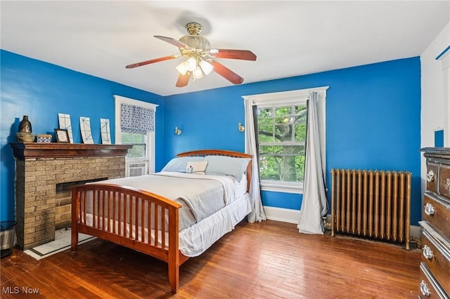 1575 E 108th St, Cleveland, OH 44106 - bedroom with radiator heating unit, hardwood / wood-style flooring, a fireplace, and a ceiling fan