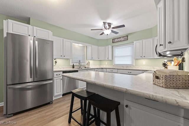 4000 Kenneth Rd, Stow, OH 44224 - kitchen with stainless steel appliances, white cabinetry, ceiling fan, a peninsula, and light wood-type flooring