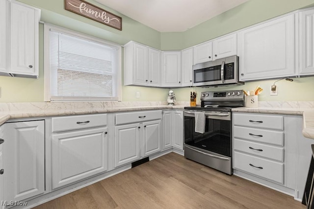 4000 Kenneth Rd, Stow, OH 44224 - kitchen with appliances with stainless steel finishes, white cabinets, and light wood-type flooring