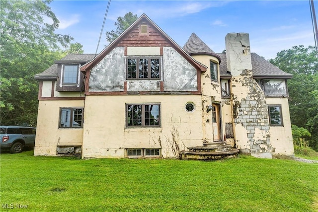 202 N State St, Rochester, OH 44090 - back of house featuring stucco siding, a lawn, a chimney, and a shingled roof