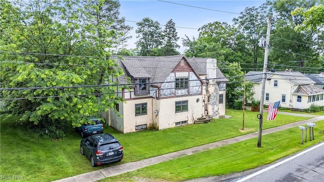 202 N State St, Rochester, OH 44090 - tudor house featuring stucco siding, a front lawn, and a balcony